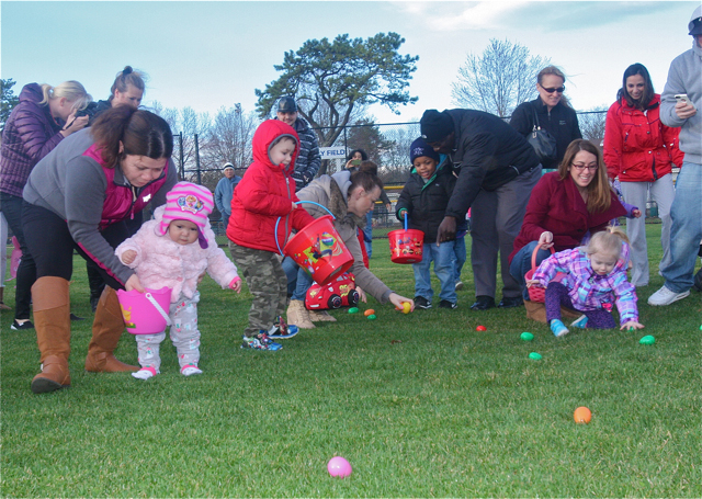 Tina Vasquez (far left) and 1-year-old daughter Alison of Riverhead race to collect eggs. (Credit: Barbaraellen Koch)