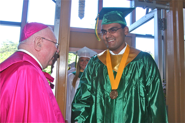 Valedictorian Elison Louis greets Bishop William Murphy. (Credit: Barbaraellen Koch)