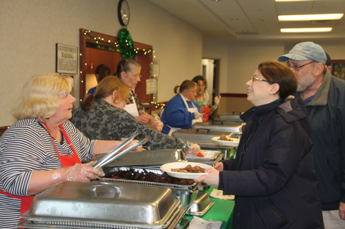 PAUL SQUIRE PHOTO | Volunteers serve up some sausage at Sunday's breakfast fundraiser.