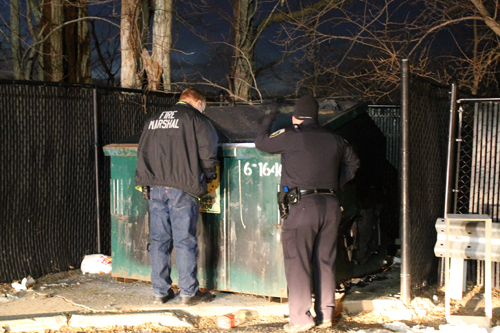 PAUL SQUIRE PHOTO | Riverhead authorities investigate the latest dumpster fire in Riverhead Sunday evening.