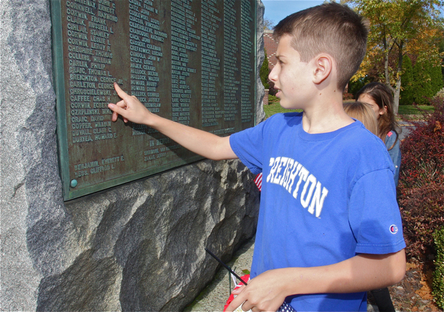 Mark Creighton, 10, of South Jamesport finds his great grandfather's name on the World War I Memorial. (Credit: Barbaraellen Koch)