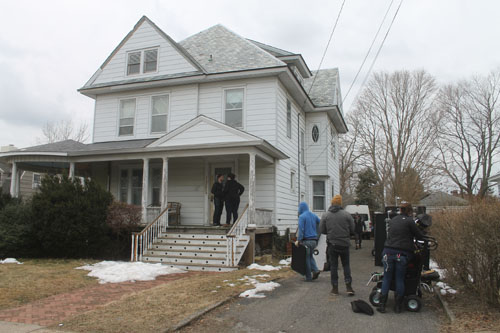 PAUL SQUIRE PHOTO | Film crews work a staging area outside an Ostrander Avenue home in Riverhead Tuesday morning.