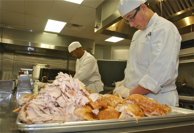 Matthew Kollmeier of Northport (right) and Jason Thomas of Riverhead carving up some of the over 250 pounds of roasted turkey. (Credit: Barbaraellen Koch)