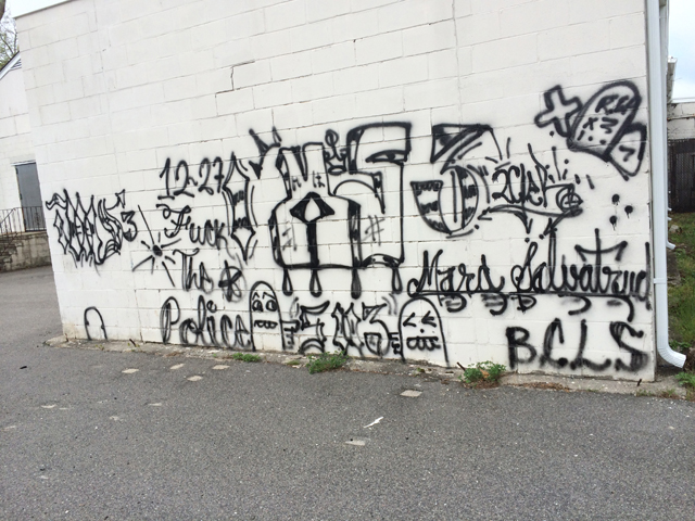 MS-13 tags on the side of a building where a Riverhead teen was spotted making graffiti Saturday. (Credit: Grant Parpan) 