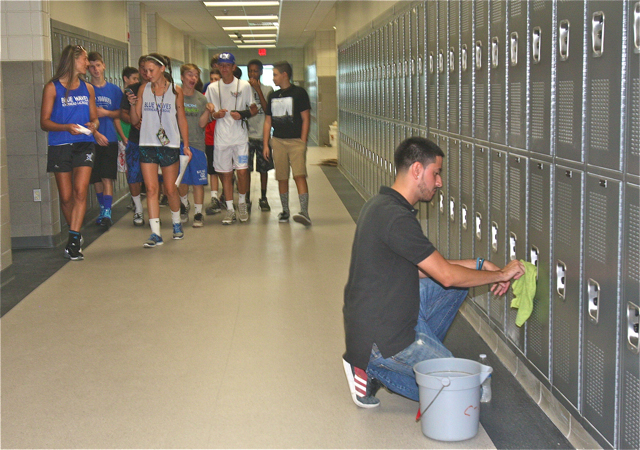 Custodian Brandon Arrizza cleans some of the lockers in the new wing as a goup of Freshman get a tour Friday. There are 2,000 new lockers in the school.