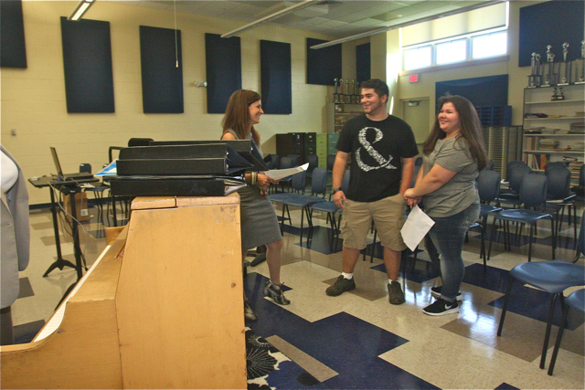 Chorus teacher Dena Marie Tishim talks with former student Brian Aguilar and his sister Anna an incoming freshman.