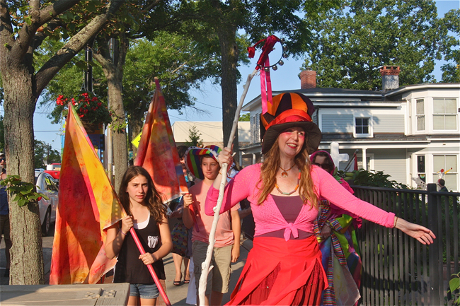 Performance artist Robyn Bellos Pirito of Huntington leads a "Peaceful Planet Procession" from East Main Street to the River and Roots Community Gardent to hang peace flags. She is part of "The Adventures of Gingerella" with mixed media artist Ginger Balizer-Hendler. (Credit: Barbaraellen Koch)
