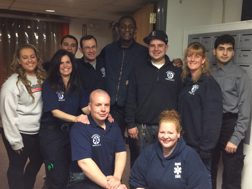 Lonnie Hughes (center, back row) stands with some of the EMTs who saved his life at Crazy Sports Night weeks ago. (Credit: Riverhead Volunteer Ambulance Corps)