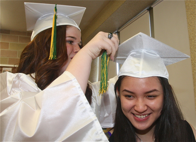 Jessica Marmelstein of Coram helps classmate City Le of MIller Place with her tassel. (Credit: Barbaraellen Koch)