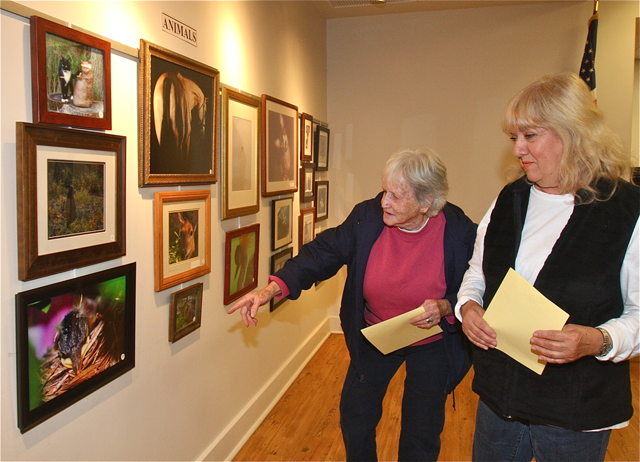 Roxie Shepish (left) and Theresa Gallo, both of Riverhead, admiring the animal photo entries. Ms. Shepish won a second place award in the abstractions/manipulations category. (Credit: Barbaraellen Koch)