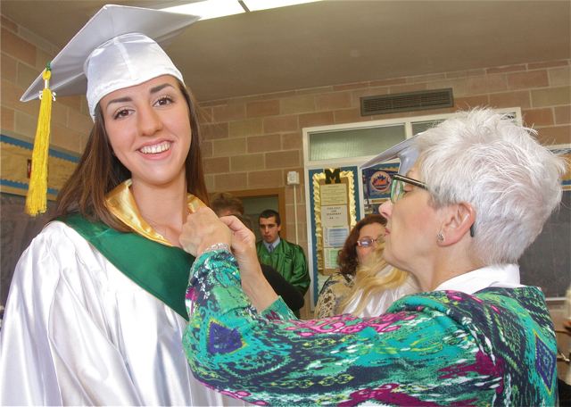 Monica Healy of Wading River gets some help with her gown from Latin teacher Sandra Bertolotti. (Credit: Barbaraellen Koch)