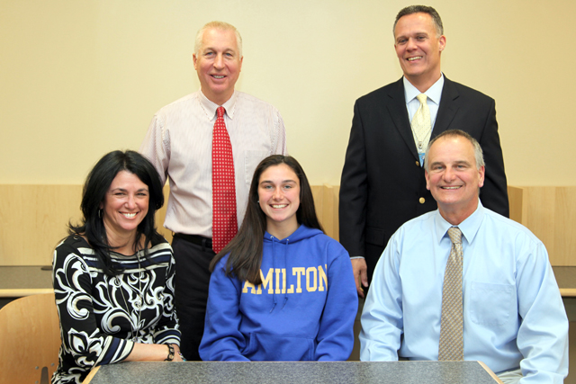 Riverhead senior Katie McKillop was joined be her parents Alice and Dave, as well as athletic director Bill Groth (standing, left) and high school principal Charles Regan for a signing ceremony. (Credit: Riverhead Schools)