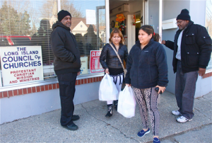Yamileth and Maritza Carbajal leave LLIC Friday afternoon as clients Anthony Thomas (left) and Thomas Anderson, both of Riverhead, wait to go inside.