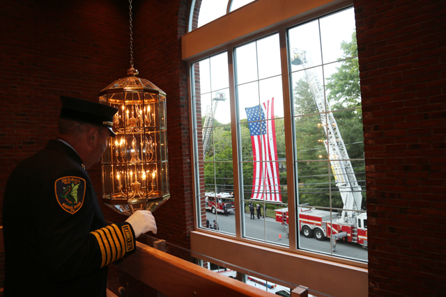 A Wading River fireman looks out the window to the American flag. (Credit: Nicole Smith)