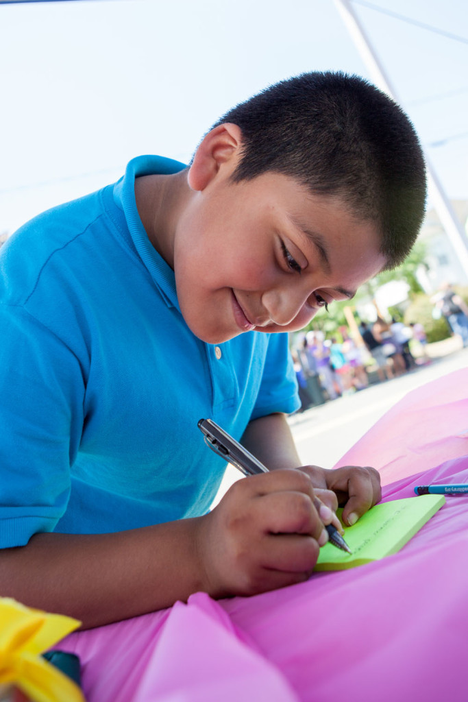 Jonathan Gochez, 10, of Riverhead writes a secret message to be placed in the time capsule. (Credit: Katharine Schroeder)