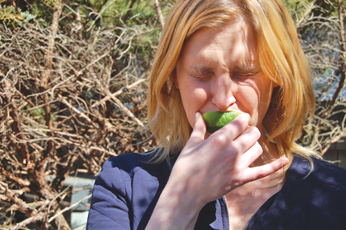 Reporter Cyndi Murray makes a sour face while biting into a lime outside the newsroom last Thursday. (Credit: Joseph Pinciaro)