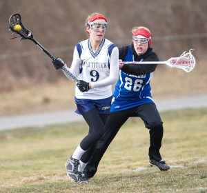 GARRET MEADE PHOTO | Katie Hoeg, who had 6 goals and 3 assists in Mattituck/Greenport/Southold's season-opening win, trying to maneuver around Riverhead's Isabella LoPiccolo.