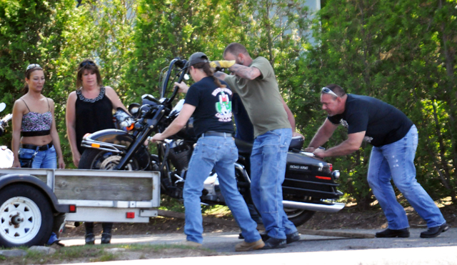 Friends load a motorcycle onto a trailer after a couple was injured riding on Sound Avenue in Calverton Sunday afternopon. (Credit: Grant Parpan)
