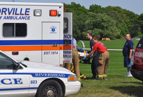 The crash victim is lifted out of the ambulance at the Delalio Sod Farm on Edwards Avenue in Calverton. (Credit: Grant Parpan)