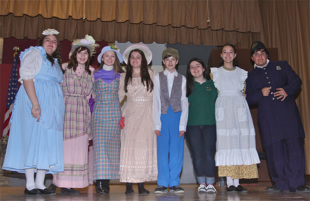 Cast members include (from left): Stephanie Spinella of Jamesport as Amaryllis, Caitlin Jacobs of Mattituck as Alma Hix, Stephanie Muller of Center Moriches as Maud Dunlop, Anne McGoldrick of East Yaphank as Mrs. Squires, Alec Kerrigan of Aquebogue as Tommy Djilas, Katherine Motlenski of Aquebogue as Zaneeta Shin, Jessica Sforza of Riverhead as Gracie Shinn, and George Flanagan of Watermill as Constable Locke. (Credit: Barbaraellen Koch)