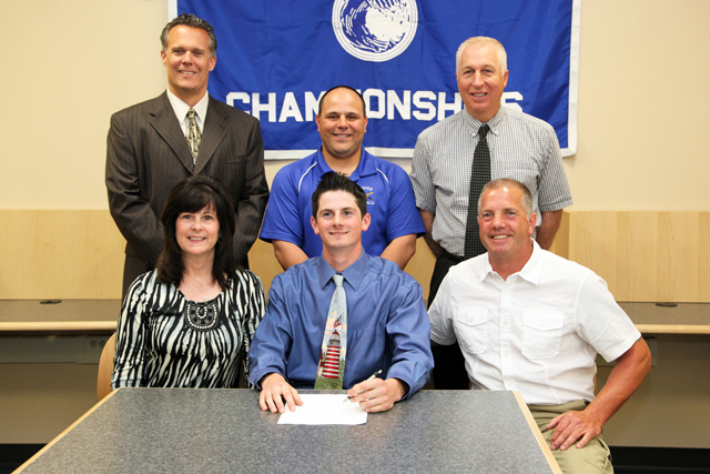 Riverhead senior Nick Herzog, pictured alongside his parents Debbie and Scott, will play baseball at the University of Massachusetts-Boston next year. High School principal Charles Regan (left), varsity coach Rob Maccone and athletic director Bill Groth joined them for a signing ceremony. (Credit: Riverhead School District)