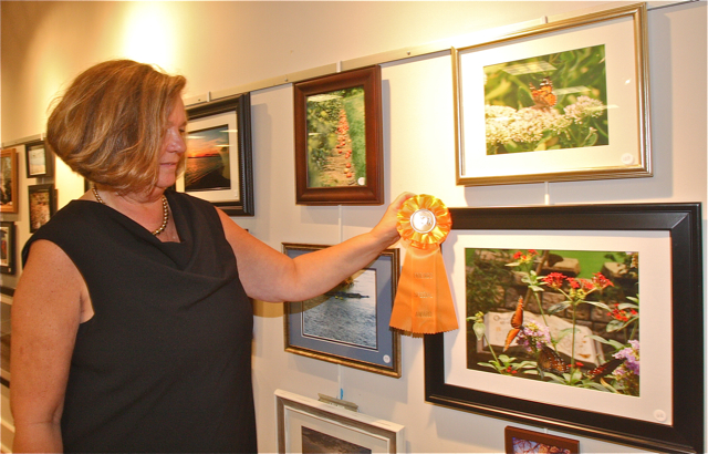 Judge Susan Romano puts the Friends Choice Award ribbon on Mary Ann Dearg's photo.