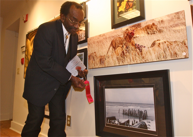 Sylvan Martin of Riverhead placing the second place ribbon on the winning photo in the nature category.