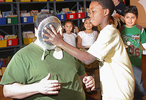 BARBARAELLEN KOCH PHOTO Fourth grader Troyshaw Burgess throws the first pie in Principal Thomas Payton's face Friday.