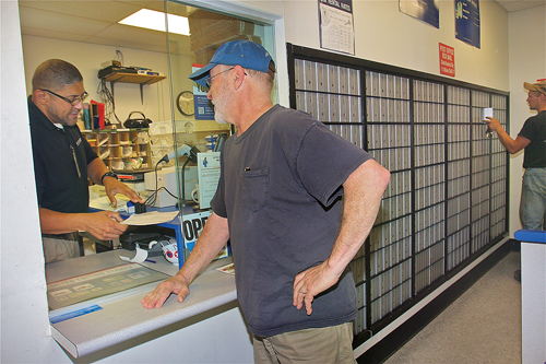Postmaster Kevin Ford helps South Jamesport resident Dan Faraone Tuesday morning. (Credit: Barbaraellen Koch)