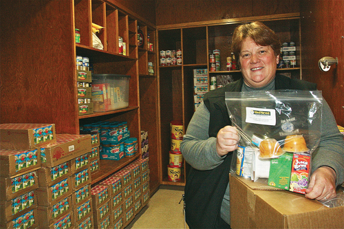 Phillips Avenue Elementary School principal Debra Rodgers holds a package of Island Harvest food that students take home in their backpacks for the weekend. The new food pantry opens today; hours will be from 6:30 to 8 p.m. the second and fourth Thursday of each month. (Credit: Barbaraellen Koch)