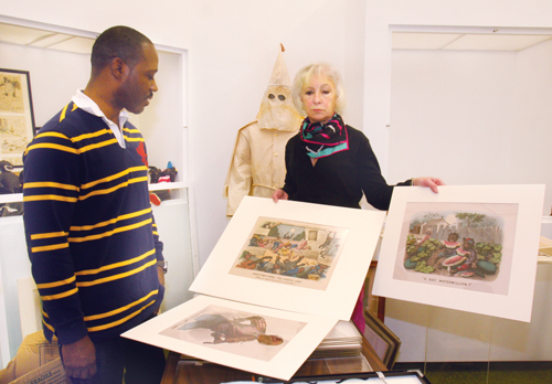 BARBARAELLEN KOCH PHOTOCurator David Byer-Tyre and SCHS executive director Kathy Curran holding  Currier and Ives 'Dark Town' series prints.