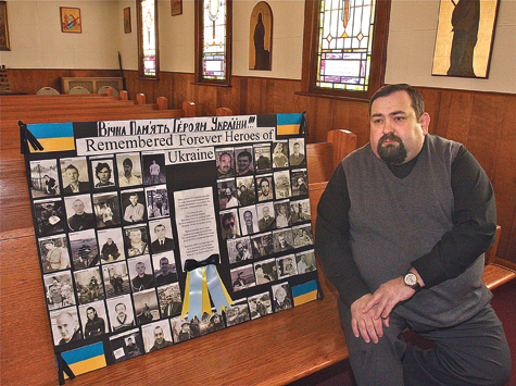 Father Roman Malyarchuk with the poster his parishoners made to honor those who were killed in the protests in Kiev, the capital of Ukraine. (Credit: Barbarallen Koch)