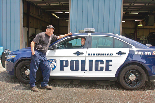 Mike Curtis, Riverhead Town's lead mechanic, with Officer Doug Geraci at the town's municipal garage, where Mr. Curtis spent 50 to 60 hours outfitting the department's new car for patrol use. (Credit: Barbaraellen Koch)