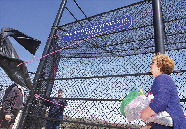 Marion Venetz (right) helping to unveil the sign naming field two at Veteran's Memorial Park in Calverton after her son during the Little League opening day ceremonies last year. (Credit: Barbaraellen Koch, file)