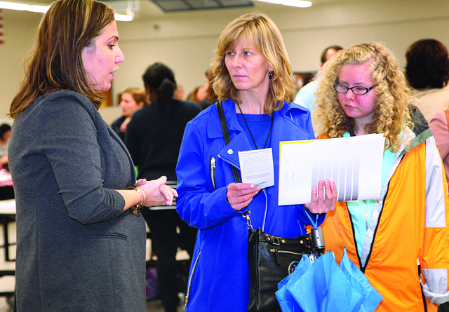 RIVERHEAD SCHOOLS COURTESY PHOTORiverhead High School student Kerri Koeberl (right) with her mother Michaela at the Transition Fair in 2014 speaking with one of the agency representatives who participated.