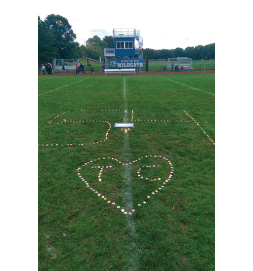 A candlelit tribute to Tom Cutinella made during a vigil at the Shoreham-Wading River football field last Thursday. (Credit: Thomas Baker)