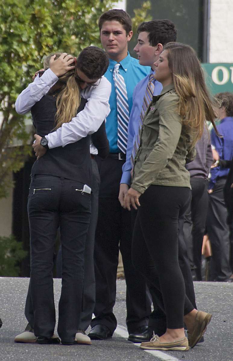 Friends embrace outside the funeral, where more than a thousand attendees paid their respects to Tom Cutinella. (Credit: Paul Squire)