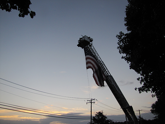The Riverhead Fire Department hangs the American flag. (Credit: Tim Gannon)