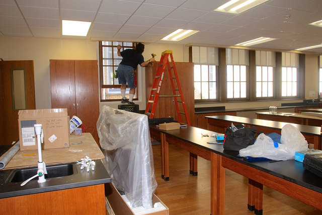Pulaski Street School's custodian Claude Pragliola installs the shades in the new science lab.