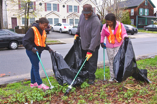 Craig Scott and his daughters Aneisha, 16, (left) and Shayla, 12, of Riverhead worked on cleaning up an empty wooded lot on the western end of Lincoln Avenue during last April's cleanup. (Credit: Barbaraellen Koch, file)