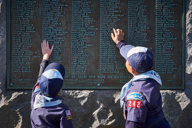 Miles Hatcher-Robertson and Lorenzo McFarlin of Cub Scouts Pack 242 examine the memorial.