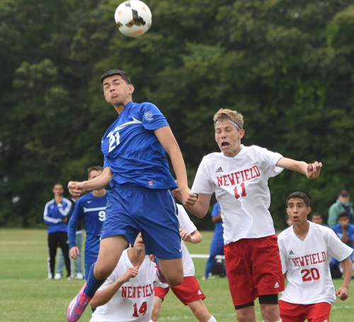 Riverhead's Jonathan Perez rises to head a corner kick while being challenged by Newfield's Connor Timmonds (10). (Credit: Garret Meade)