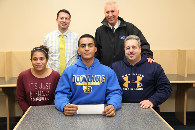 Riverhead senior John Roca was joined by his sister Jenna and father John, as well as varsity coach Vic Guadagnino (standling, left) and athletic director Bill Groth for his signing. (Credit: Riverhead schools)