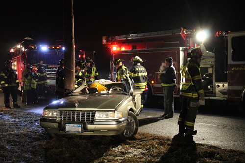 PAUL SQUIRE PHOTO | Wading River firefighters cut a man out of a crashed car late Monday night.
