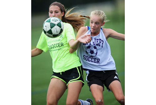 Shoreham-Wading River's Alex Kuhnle, left, and Port Jefferson's Jillian Colucci competing for possession of the ball during a summer league game. (Credit: Garret Meade)