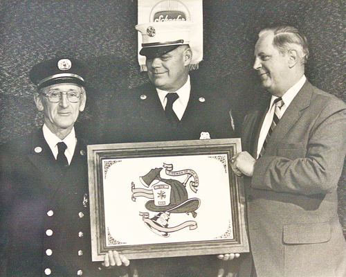 Harold 'Smokey' Schaefer (left) with fire chief Bobby Taylor (center) as he was presented with the 1979 Fireman of the Year award. (Riverhead Fire Department courtesy photo)