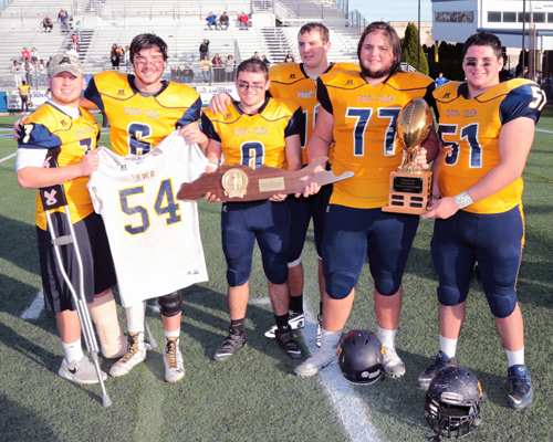 Team Captains display the Long Island Championship Trophy's (left to right) Kevin Cutinella #7, Jason Curran #6, Chris Rosati #8, Ethan Wiederkehr #40, James Puckey #77 and Dalton Stalzer #51. Shoreham-Wading River defeated Locust Valley 35-7 in the Long Island Division III Championship game at James M. Shuart Stadium, Hofstra University on Nov. 27, 2015. By Daniel De Mato