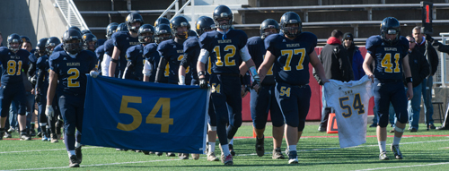 The late Tom Cutinella's retired No. 54 jersey held a prominent place as the Shoreham-Wading River players marched onto the field before the game. (Credit: Robert O'Rourk)