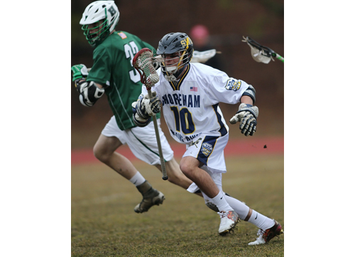 Steve Wiendler, carrying the ball forward, collected 10 ground balls and an assist for Shoreham-Wading River in its season-opening win over Harborfields. (Credit: Garret Meade)