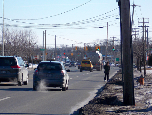 A woman makes her way up Route 58 on Tuesday morning before stepping into a parking lot. (Credit: Joseph Pinciaro)